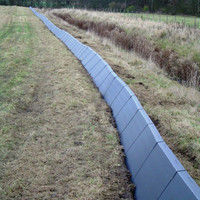 Green textured Herpetosure one-way fencing panel fitted at a 45-degree angle along a site boundary